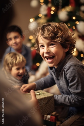 little boy opening pile of presents and smiling with excitement while his fam...