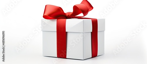 The beautifully designed white gift box, adorned with a red ribbon and bow, sat isolated in white background, ready for the Christmas celebration or a loved one's birthday present, making it perfect
