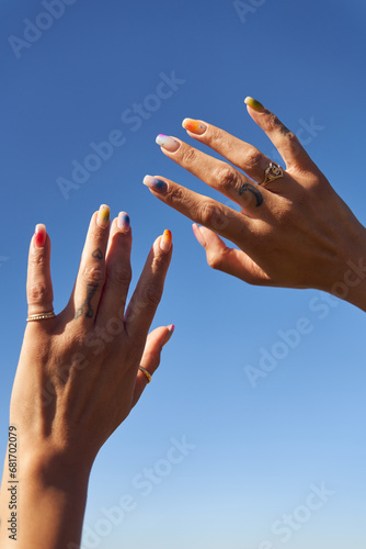 Portrait of Woman Hand in the Sky with Colorful Nail Art