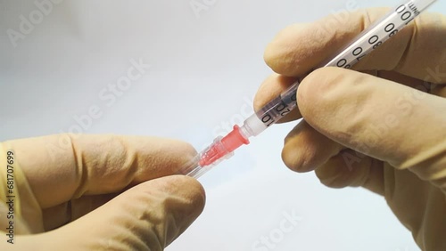 Hands in medical gloves holding an insulin syringe with medicine, close-up