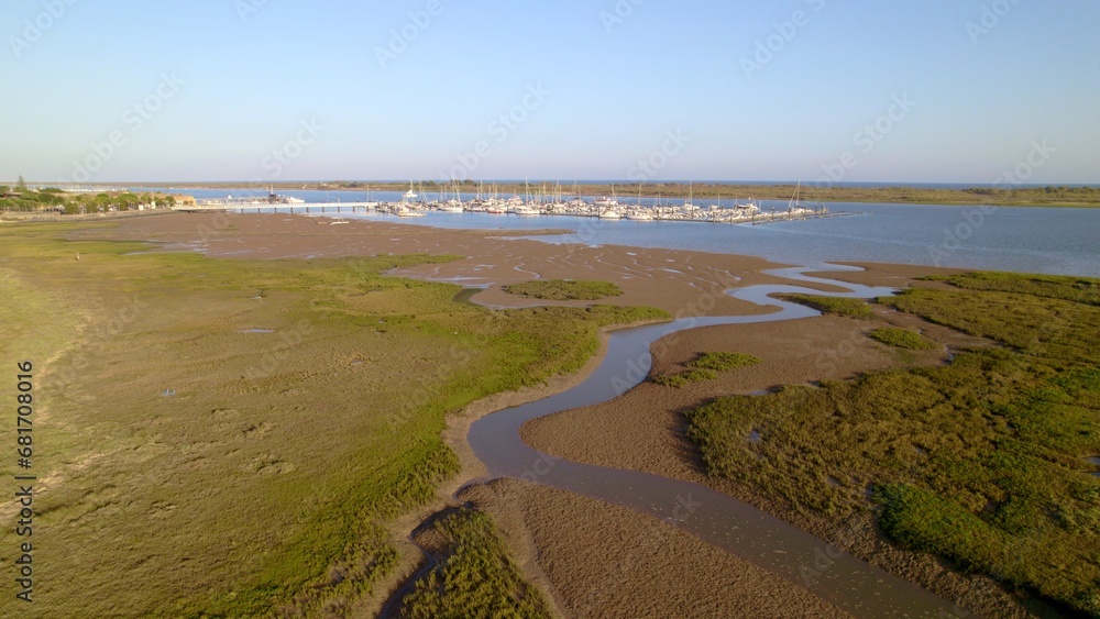 Sunset at the marina. Boats in the estuary with the sea in the background. Aerial view from drone with many boats of different types. El Rompido. Huelva. Andalusia. Spain.