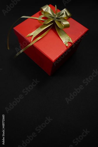 Red gift box on black background. It has space to write text. Suitable for advertising during shopping seasons