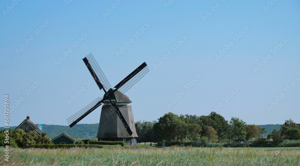 A traditional Dutch windmill standing on a field in the Netherlands