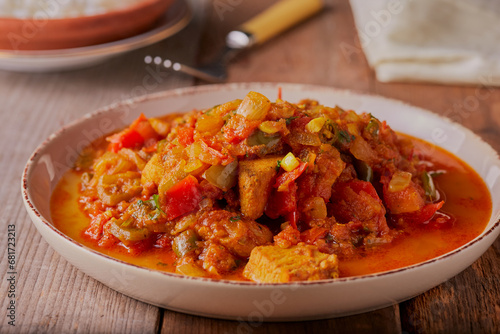 Traditional spicy hot Indian curry dish in a rustic setting.