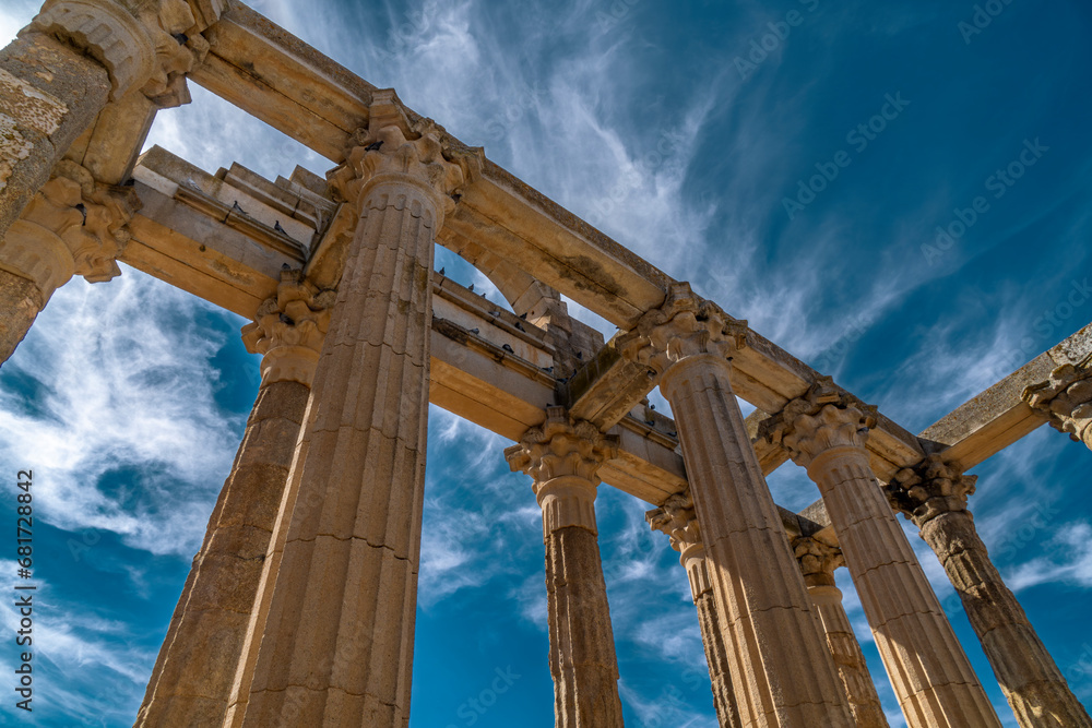 View from below of the marble columns with Greek capitals of the Roman temple of Diana with doves perched on the frontispiece. Merida, Spain.