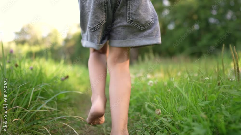 girl running on the grass in the park in summer. happy family childhood dream concept. a little girl with bare feet runs along the green grass in a summer park. child running down the path lifestyle girl running on the grass in the park in summer. happy family childhood dream concept. a little girl with bare feet runs along the green grass in a summer park. child running down the path lifestyle