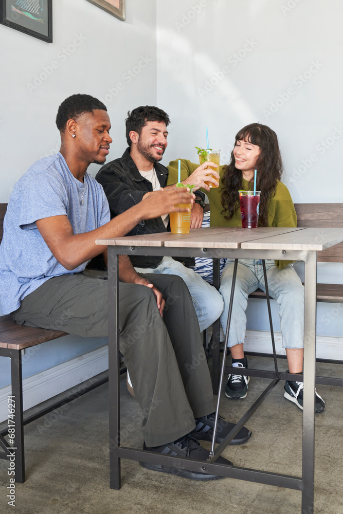 Fototapeta premium Friends drinking tea at cafe from plastic cups with straws