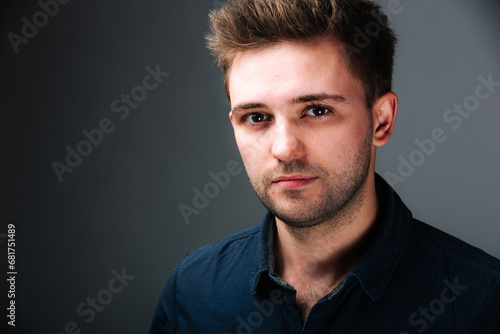 A man in a black shirt is posing for a picture. A Stylish Man in a Black Shirt Strikes a Confident Pose for a Captivating Photograph
