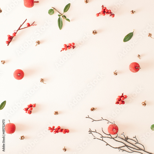 Creative bright pattern made of branches with red berries and pine cones. Christmas concept. Flat lay.