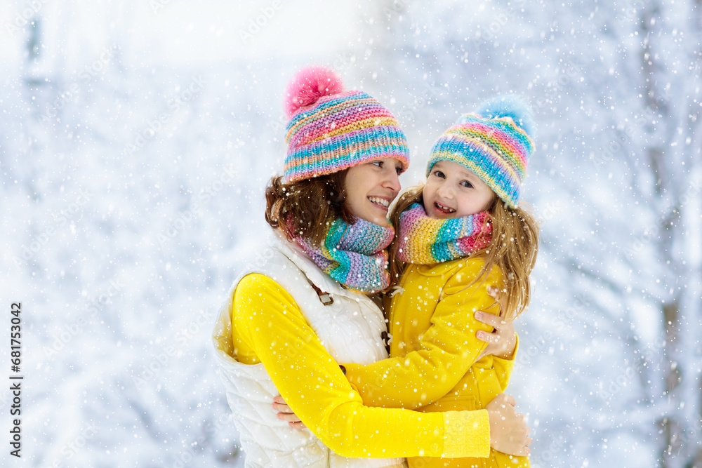Mother and child in knitted winter hats in snow. Mother and child in knitted winter hats in snow.