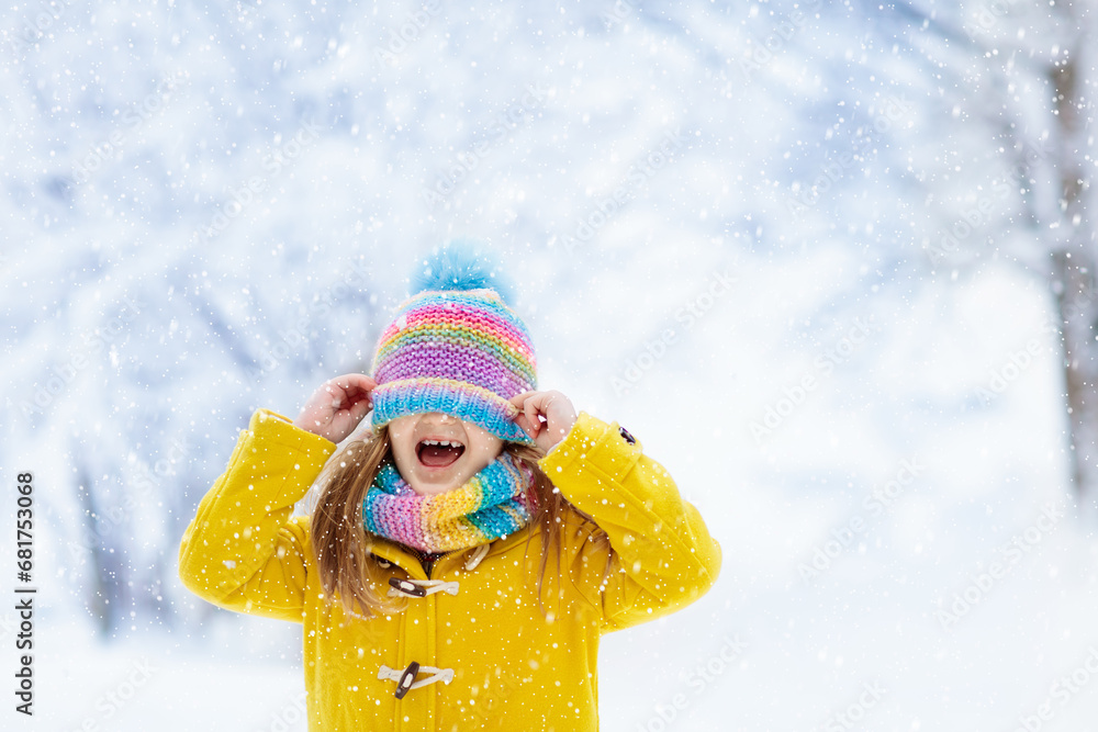 Child playing in snow on Christmas. Kids in winter Child playing in snow on Christmas. Kids in winter