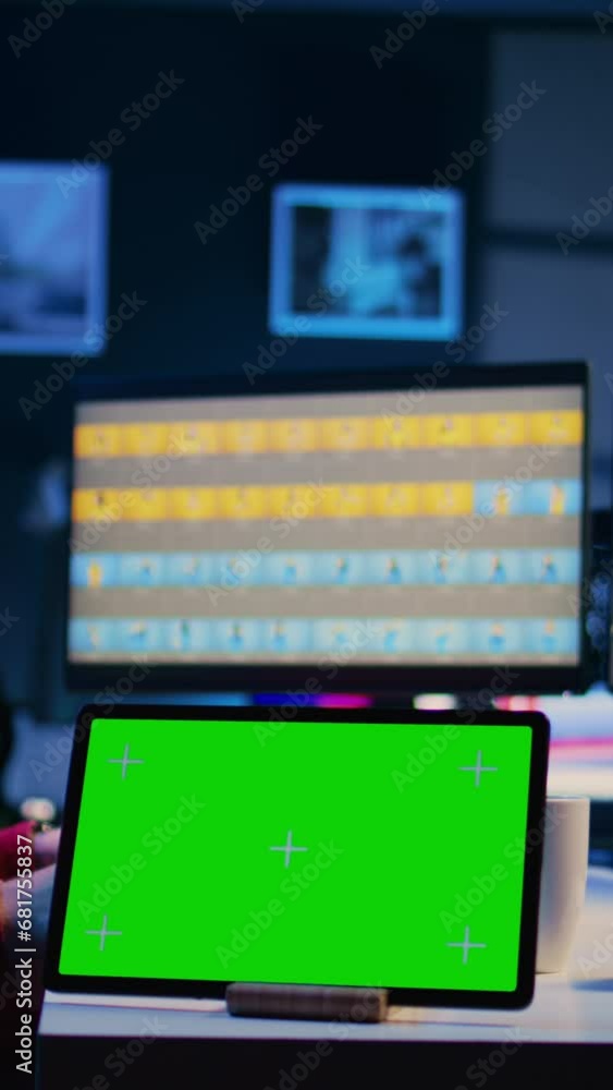 Vertical video Green screen tablet on desk in photography studio next to photo editor color correcting images in retouching software. Photographer selecting best pictures for editorial content next to Vertical video Green screen tablet on desk in photography studio next to photo editor color correcting images in retouching software. Photographer selecting best pictures for editorial content next to
