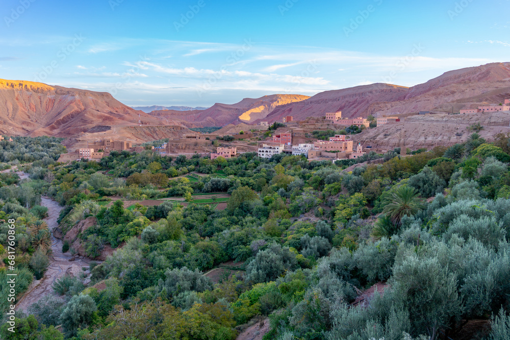 Photo of the Dades Gorge in Morocco. Photo at sunset with blue sky. Terracotta-colored buildings typical of the area.