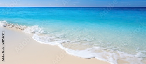 The sun's light shone brightly on the white sandy beach, creating a tropical paradise as the waves crashed against the shore, their blue hue blending perfectly with the ocean's vast expanse. The