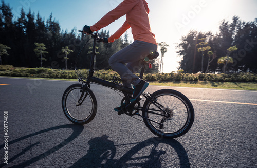Riding folding bike on sunny seaside road © lzf