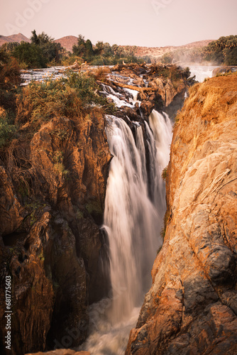 Epupa Falls, Kunene, Namibia, in warm, golden light. Epupa Falls is a series of large waterfalls formed by the Kunene River on the border of Angola and Namibia.