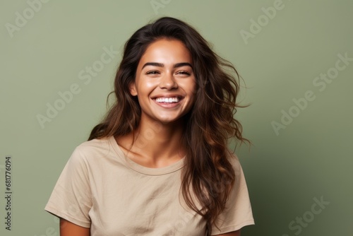 Portrait of a happy young woman smiling at camera over green background © Igor