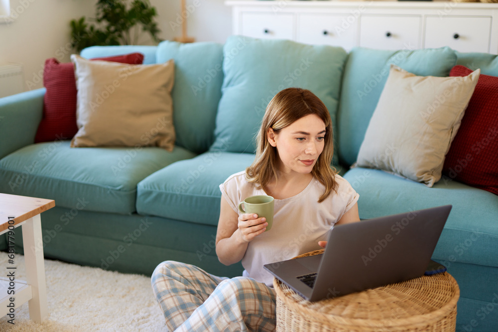 Beautiful woman surfing the net on the laptop during her coffee time at home Beautiful woman surfing the net on the laptop during her coffee time at home