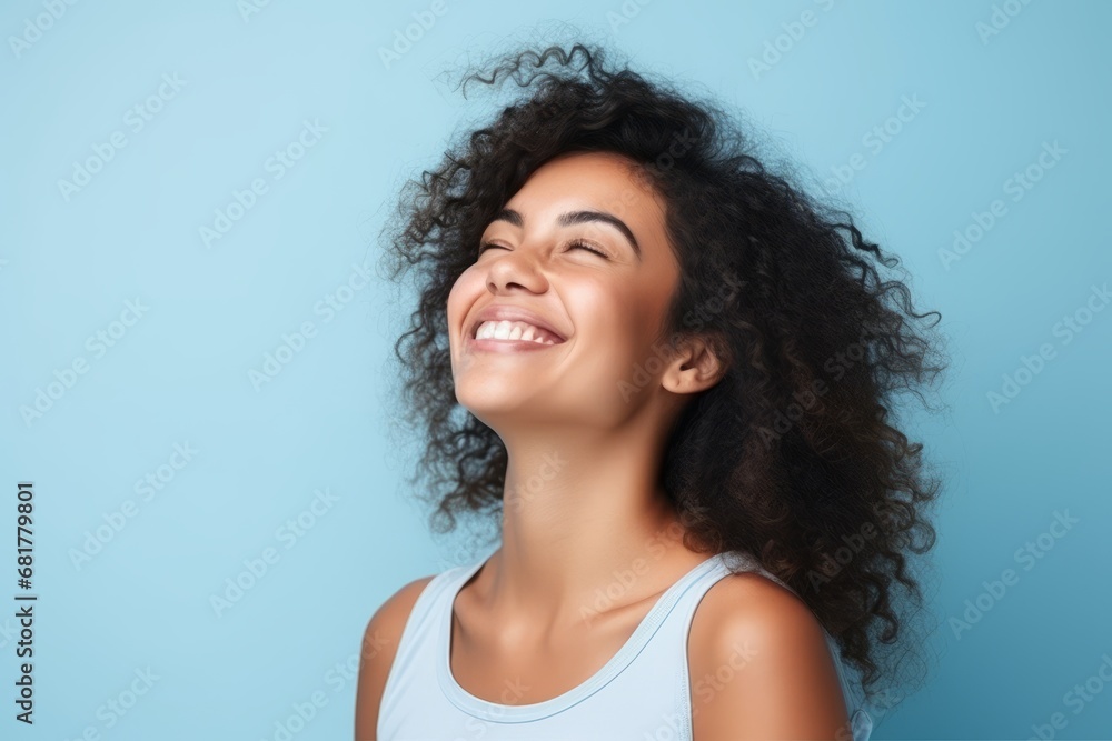 Portrait of a beautiful young african american woman laughing over blue background Portrait of a beautiful young african american woman laughing over blue background
