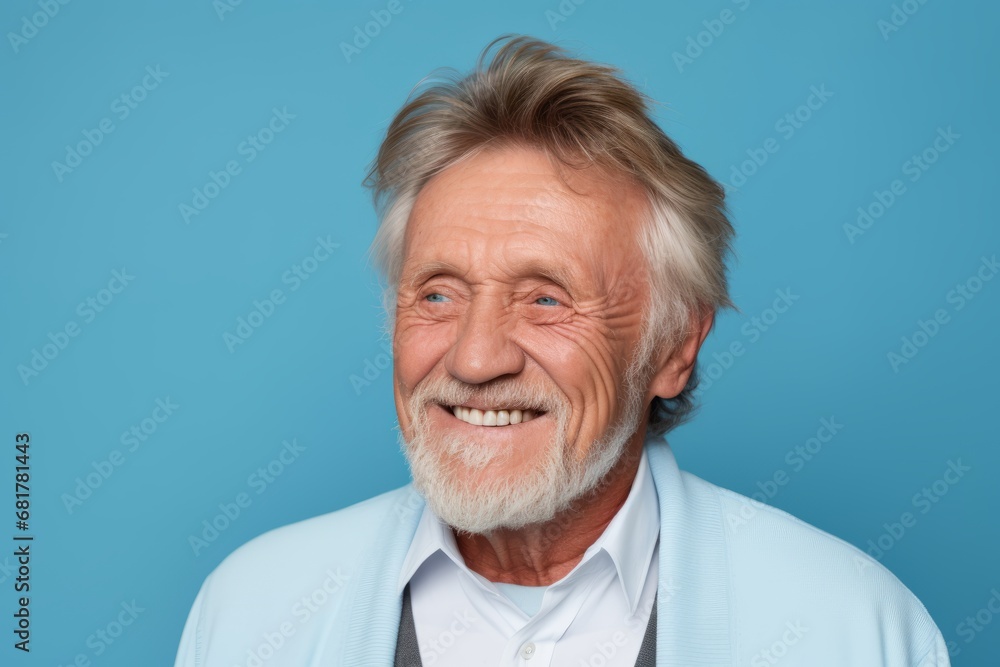 Portrait of happy senior man looking at camera and smiling against blue background Portrait of happy senior man looking at camera and smiling against blue background