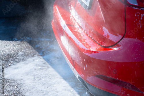 Back of a red car being washed.