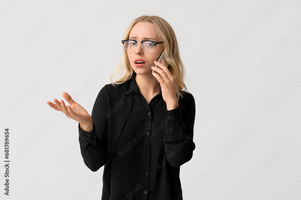 Pretty young businesswoman talking by phone on white background Pretty young businesswoman talking by phone on white background
