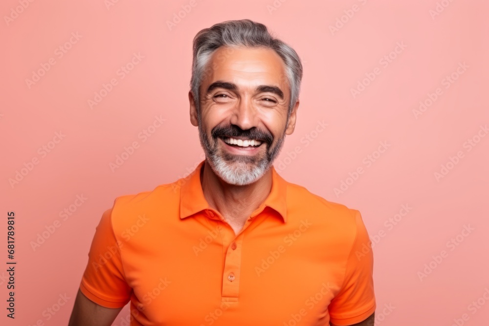 Portrait of a happy senior man looking at camera on a pink background