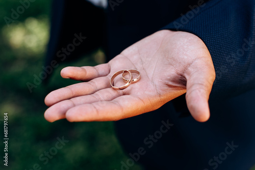 the groom holding two rings on hand