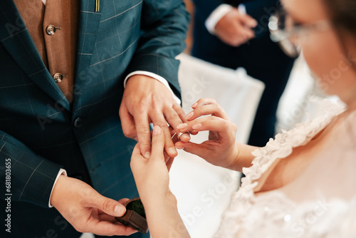 beautiful shot of the hands of two young people who promise love and fidelity in the church and exchange wedding rings, love, wedding, church, wedding rings, promises photo