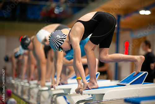 Swimmer girl start from the starting table in the pool
