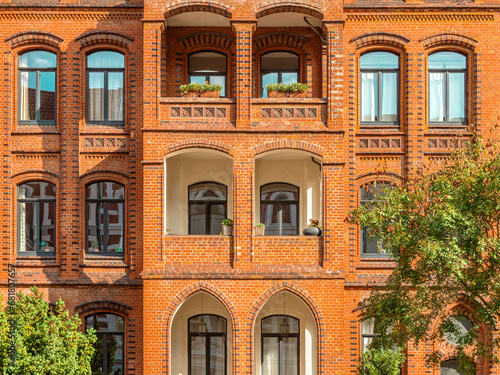 Facade of typical residential red bricks building with arched windows. Apartment house in Hannover, Germany