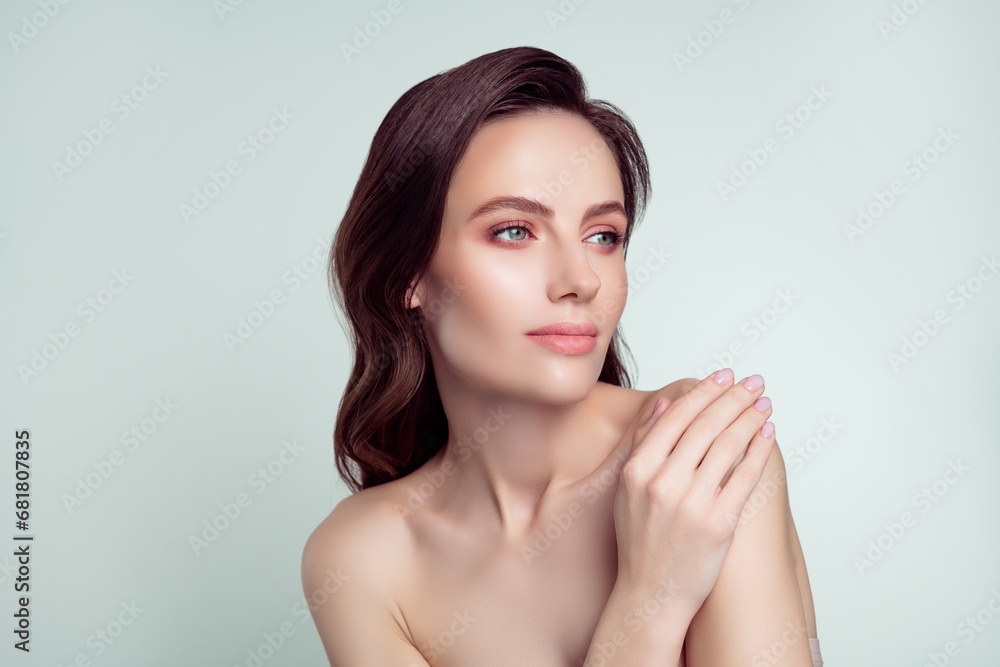 Photo portrait of pretty young girl look empty space touch shoulder spa salon isolated on light gray color background Photo portrait of pretty young girl look empty space touch shoulder spa salon isolated on light gray color background