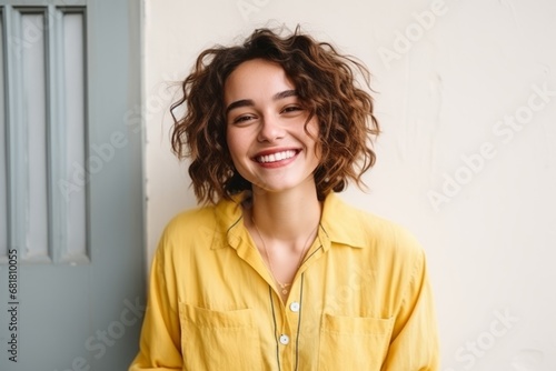 Portrait of a beautiful young woman with curly hair smiling at the camera © Igor