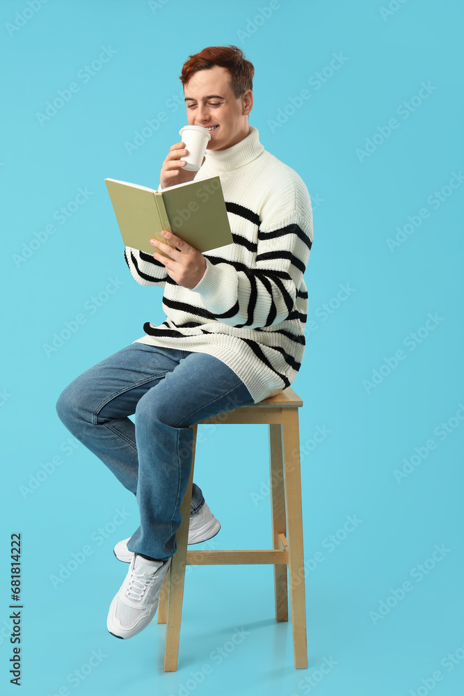 Young man drinking coffee and reading book on color background Young man drinking coffee and reading book on color background