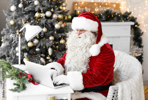 Santa Claus using laptop at...