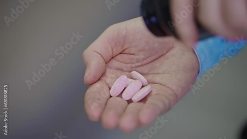 The man pours a lot of pills from a jar into his palm, close-up. Pills on hand, suicide. Male hand with medicines. Health care and medicine. Home treatment. Drug overdose. photo