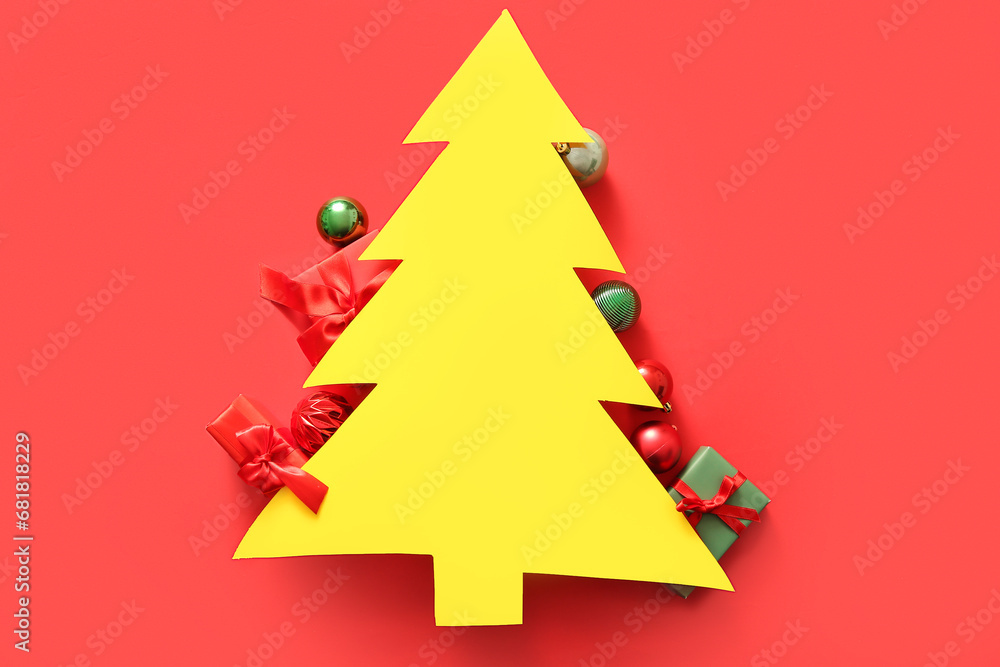 Yellow blank card in shape of Christmas tree with decor on red background Yellow blank card in shape of Christmas tree with decor on red background
