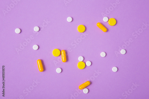 Pills and capsules on a light purple paper background. Medical treatment, pharmaceutical industry, prescription sedatives. Treatment of depression and anxiety disorders, meds, drugs
