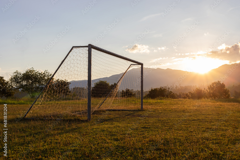 Soccer field in the countryside mountain sunset background.