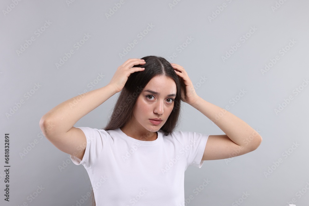 Woman suffering from dandruff problem on grey background Woman suffering from dandruff problem on grey background