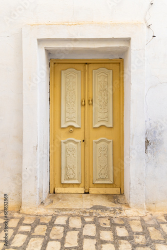 A yellow door in a white building. © Emily_M_Wilson