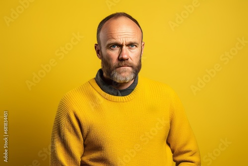 Portrait of a man in a yellow sweater on a yellow background