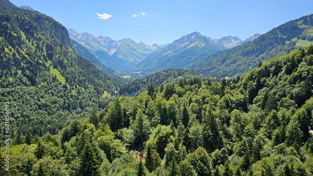 A tranquil valley surrounded by towering mountains that stretch up to the sky.