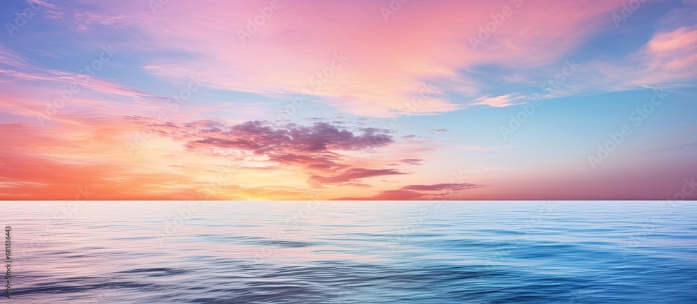 As the evening sets in, the sky transforms into a canvas of soft hues, reflecting its beauty on the calm sea's surface, where waves gently caress the shore, creating a peaceful and mesmerizing scene
