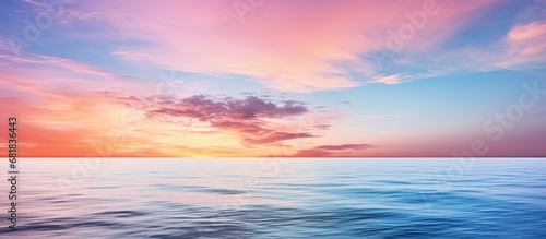As the evening sets in, the sky transforms into a canvas of soft hues, reflecting its beauty on the calm sea's surface, where waves gently caress the shore, creating a peaceful and mesmerizing scene