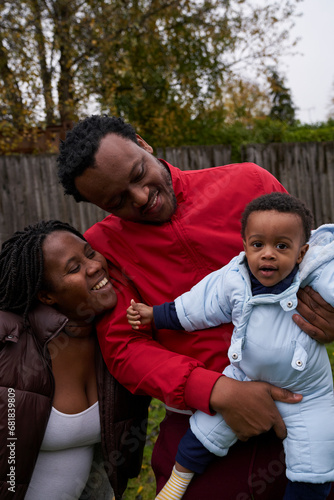 Pregant woman enjoying her garden with her son and husband