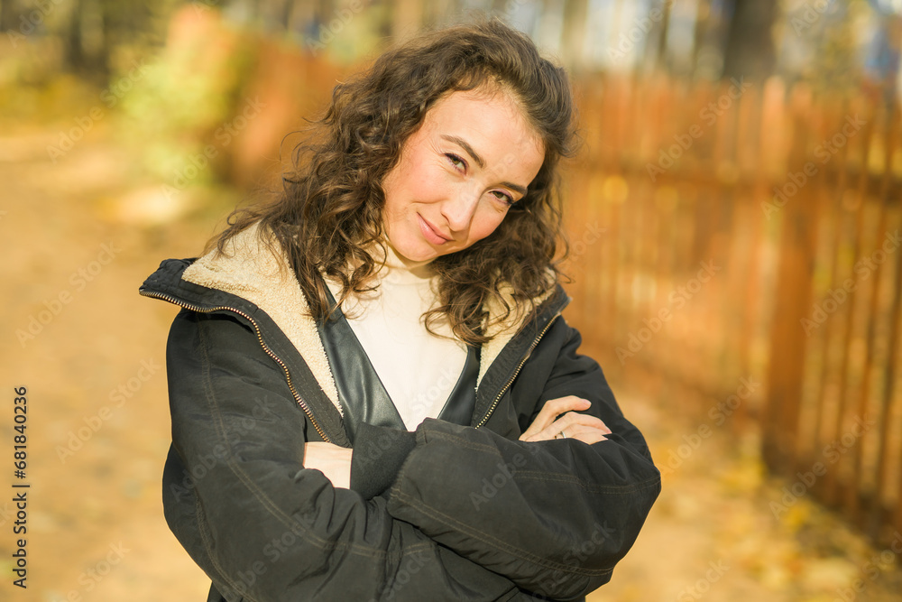 Attractive young woman walking in autumn park, happy mood and fashion style trend and curly long brown hair. Fall season and pretty female portrait copy space. Millennial generation concept Attractive young woman walking in autumn park, happy mood and fashion style trend and curly long brown hair. Fall season and pretty female portrait copy space. Millennial generation concept