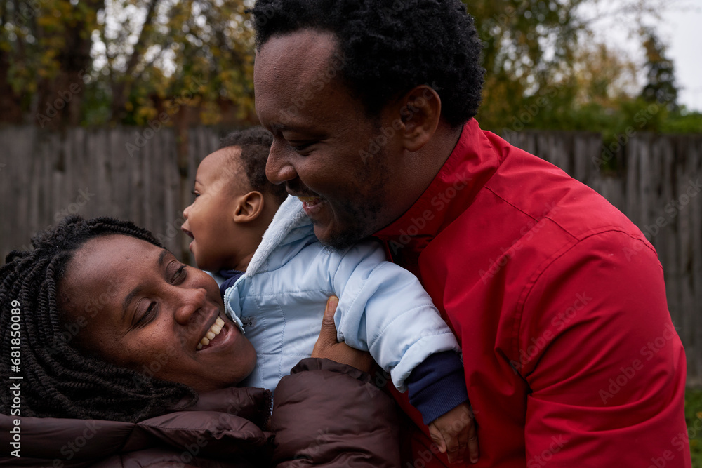 Fototapeta premium Beautiful African family enjoying their autumnal garden
