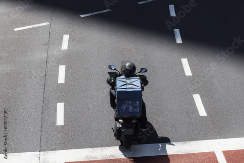 Fototapeta Naklejka Na Ścianę i Meble -  aerial view of a motorcycle courier in city traffic