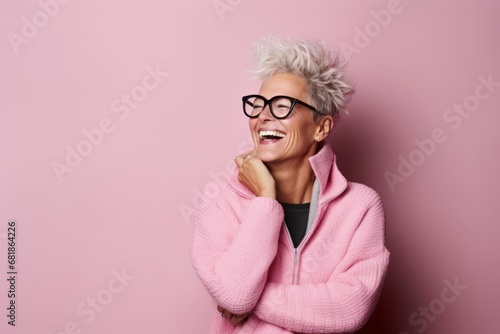 Portrait of a happy senior woman in pink sweater and eyeglasses